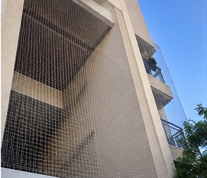 Large-scale bird netting for a commercial complex